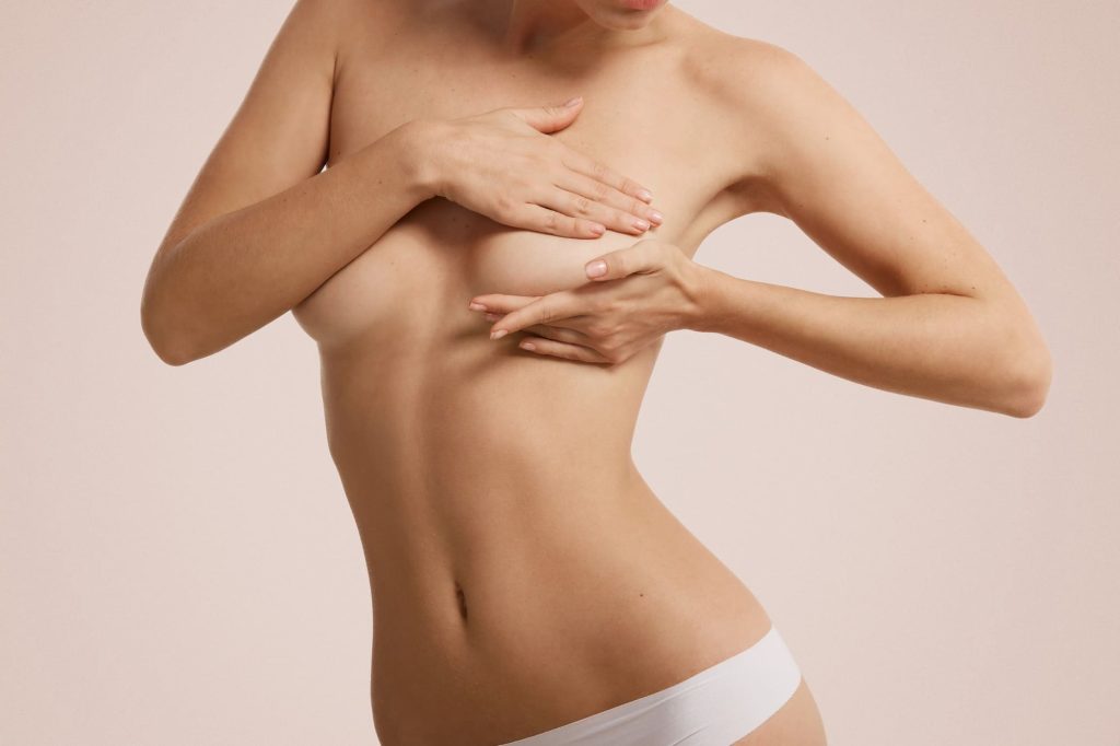 How painful is breast reconstruction surgery woman holding her boob.