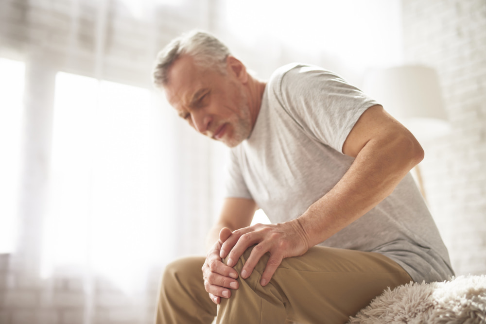 An old man suffering knee pain and bone disorder 