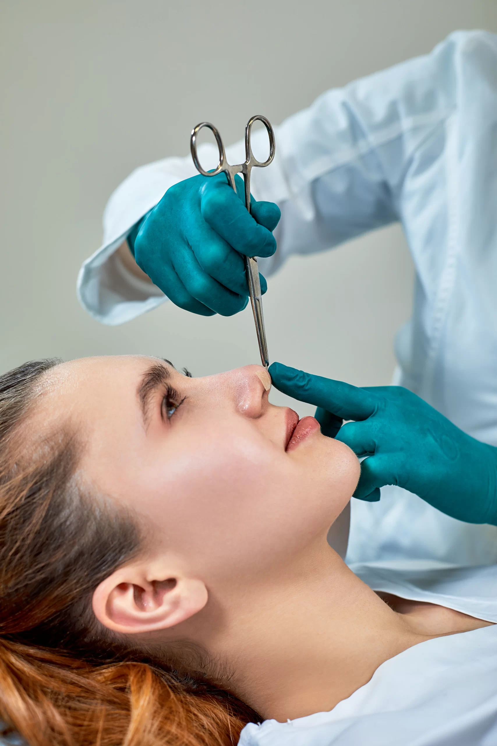lady-with-plaster-nose-doctor-examining-patients-face-after-plastic-surgery